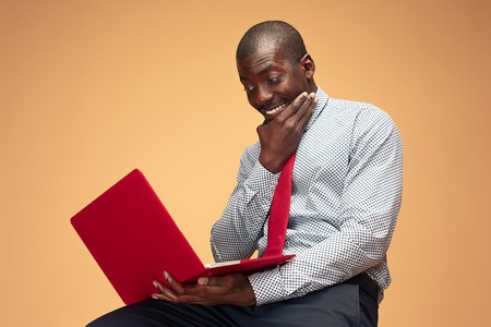 Handsome Afro American man sitting and using a laptopの写真素材
