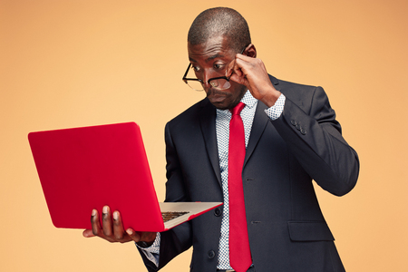 Handsome Afro American man sitting and using a laptopの写真素材