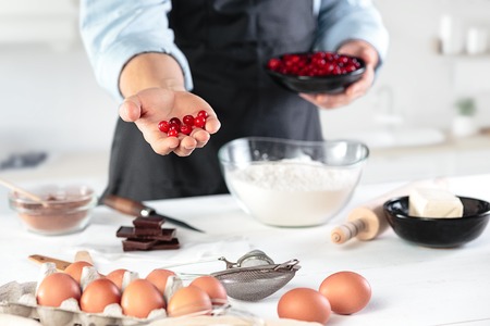 A cook with eggs on a rustic kitchen against the background of mens handsの写真素材