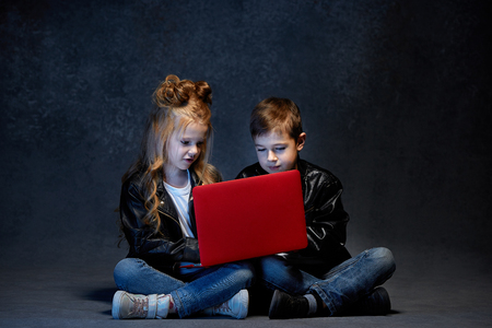 Studio shot of two children with laptopの写真素材