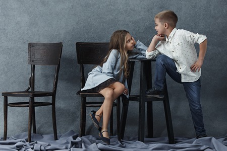 A portrait of little girl and a boy on the gray backgroundの写真素材