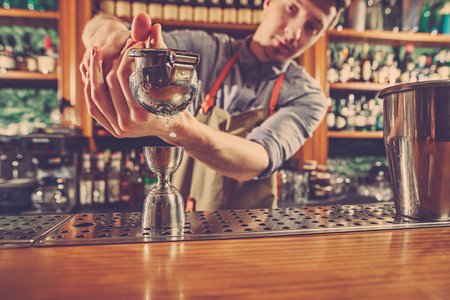 Expert barman is making cocktail at night club.の写真素材
