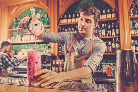 Expert barman is making cocktail at night club.の写真素材