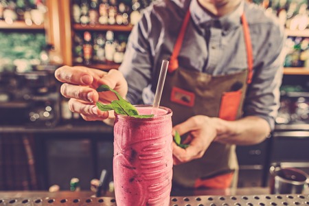 Expert barman is making cocktail at night club.の写真素材