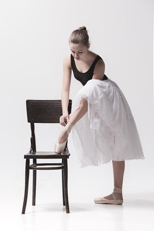 The teen ballerina in white pack posing near chairの写真素材