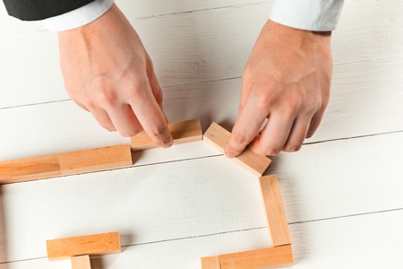 Man and wooden cubes on table. Management conceptの写真素材