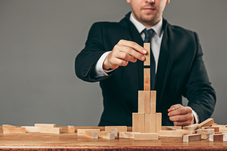 Man and wooden cubes on table. Management conceptの写真素材