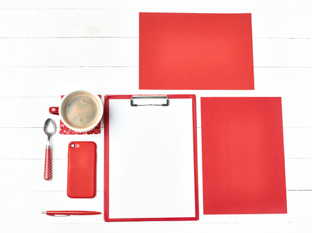 Office table desk with set of colorful supplies, white blank note pad, cup, pen on white background.の写真素材
