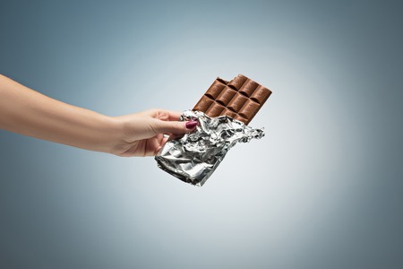 Hands of a woman holding a tile of chocolateの写真素材