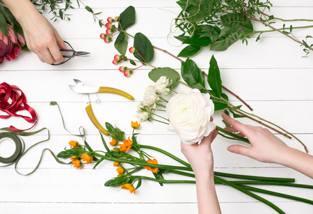 Female florist making beautiful bouquet at flower shopの写真素材