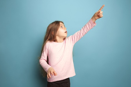 The determination. Teen girl on a blue background. Facial expressions and people emotions conceptの写真素材