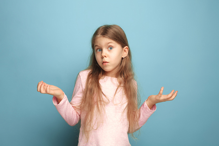 The surprise. Teen girl on a blue background. Facial expressions and people emotions conceptの写真素材