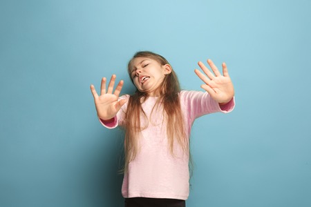 The disgust. Teen girl on a blue background. Facial expressions and people emotions concept