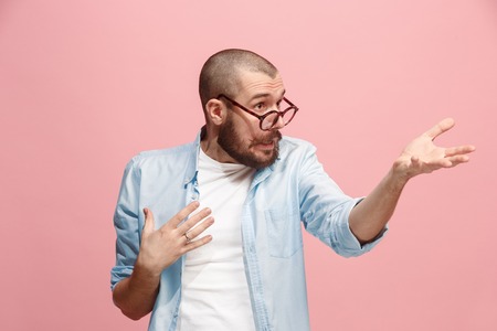 Beautiful male half-length portrait isolated on pink studio backgroud. The young emotional surprised...