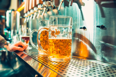 Glass of beer with barrel, bottle and fresh hops still-lifeの写真素材