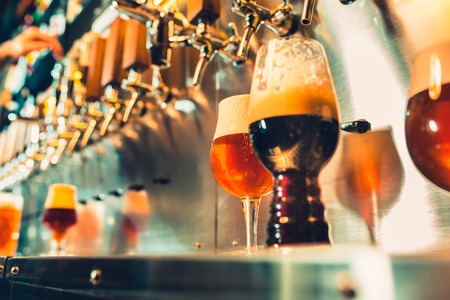 Hand of bartender pouring a large lager beer in tap.の写真素材