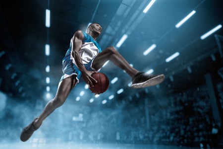 Basketball player on big professional arena during the game. Basketball player making slam dunk.の素材 [FY31096160345]