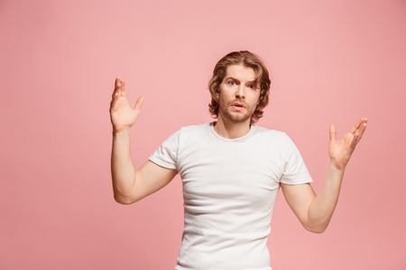 Beautiful male half-length portrait isolated on pink studio backgroud. The young emotional surprised manの写真素材