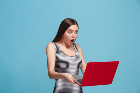 Businesswoman with laptop on blue studioの写真素材