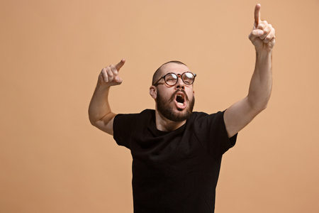 Beautiful male half-length portrait isolated on pastel studio backgroud. The young emotional surprised manの写真素材