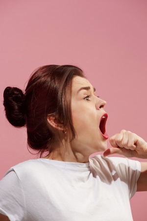 The young emotional angry woman screaming on pink studio backgroundの写真素材