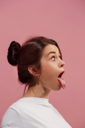 The squint eyed woman with weird expression isolated on pinkの写真素材