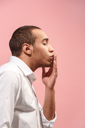 Portrait of attractive man with kiss isolated over pink backgroundの写真素材
