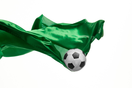 Soccer ball and Smooth elegant transparent green cloth isolated or separated on white studio background.の写真素材