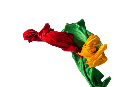 Smooth elegant transparent yellow, red, green cloth separated on white background.の写真素材