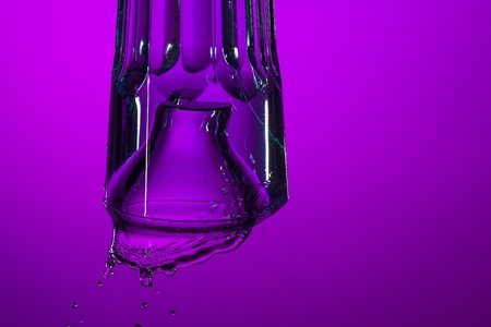 The water splashing in glass on lilac backgroundの写真素材