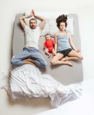 Top view of happy family with one newborn child in bedroom.の写真素材