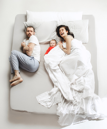 Top view of happy family with one newborn child in bedroom.の写真素材