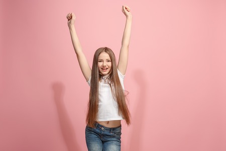 Happy success teen girl celebrating being a winner. Dynamic energetic image of female modelの写真素材