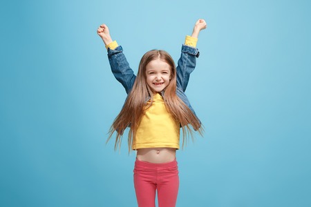 Happy success teen girl celebrating being a winner. Dynamic energetic image of female modelの写真素材