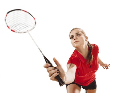Young woman playing badminton over white backgroundの写真素材