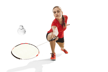 Young woman playing badminton over white backgroundの写真素材