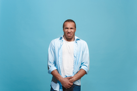 Young man with disgusted expression repulsing something, isolated on the blueの写真素材