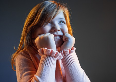 The happy teen girl standing and smiling against dark blue background.の写真素材