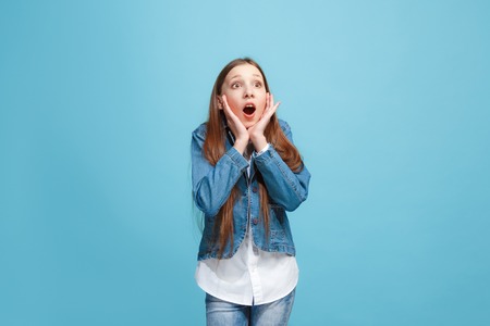 Beautiful teen girl looking suprised isolated on blueの写真素材