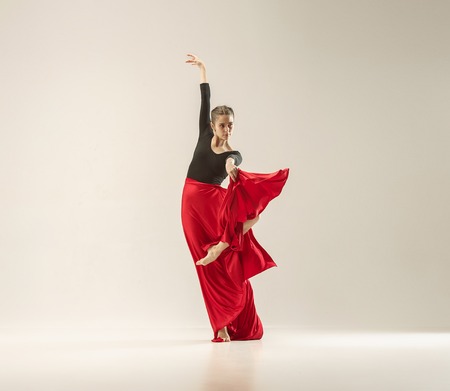 Modern ballet dancer dancing in full body on white studio background.