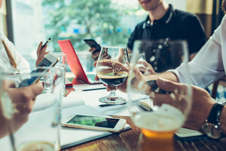 Young cheerful people smile and gesture while relaxing in pub.の写真素材