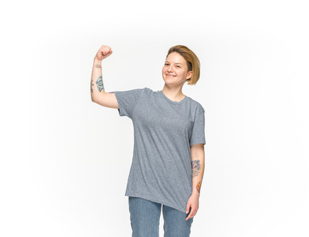 Closeup of young womans body in empty gray t-shirt isolated on white background. Mock up for disign...