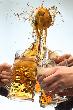 The many male hands with mugs of beer toasting on studio white background. Sport, fan, bar, pub, celebration, soccer football concept.の写真素材