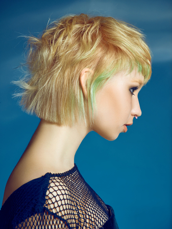 Close-up indoor portrait of lovely girl with blonde hair. Studio shot of graceful young woman with short haircutの写真素材