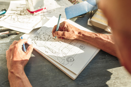 Close up man working of Architect sketching a construction project on his plane project at site construction workの写真素材