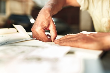 Close up man working of Architect sketching a construction project on his plane project at site construction workの写真素材