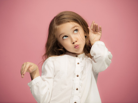 Beautiful teen girl looking suprised isolated on pinkの写真素材
