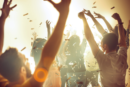 Nightlife and disco concept. Young people are dancing in club.