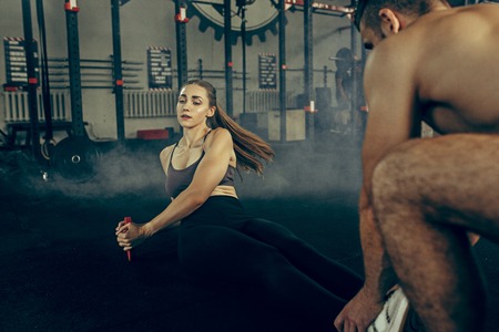 Fit young woman lifting barbells working out in a gymの写真素材