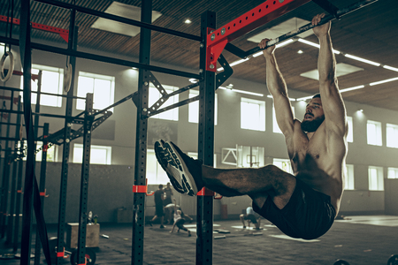 Concept: power, strength, healthy lifestyle, sport. Powerful attractive muscular man at CrossFit gymの写真素材